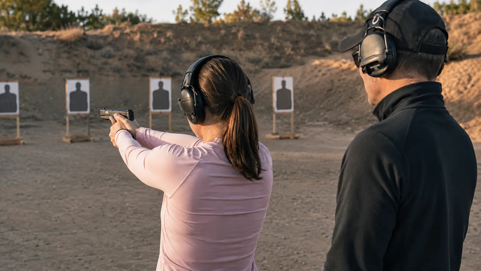 Firearms instructor coaching a woman during safe right-handed handgun training