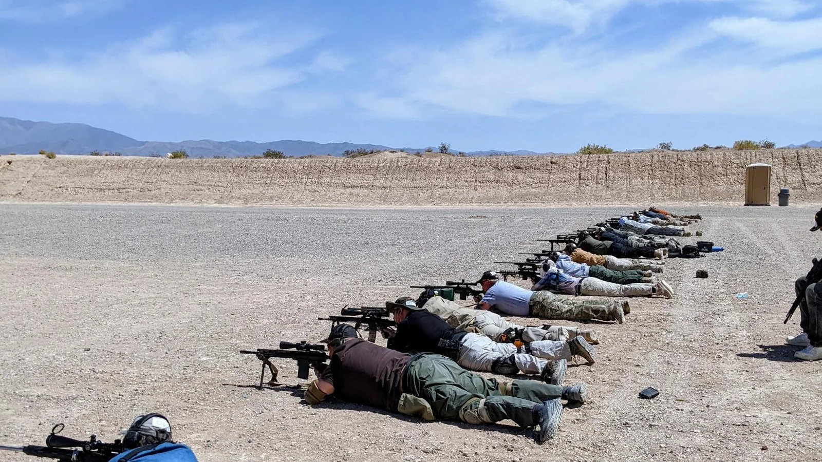 Students practicing rifle marksmanship during practical firearms training at an outdoor range