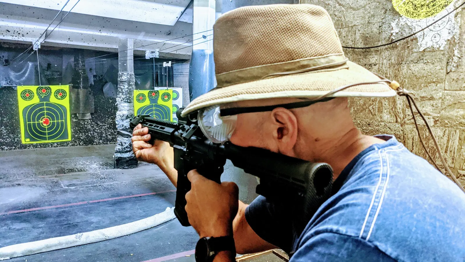 Student practicing AR-platform rifle fundamentals at an indoor shooting range